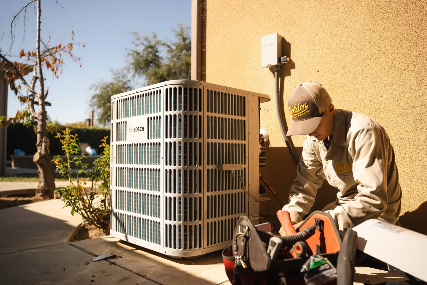 Golden Valley Heating and Air technician servicing outdoor air conditioning equipment — photo 2
