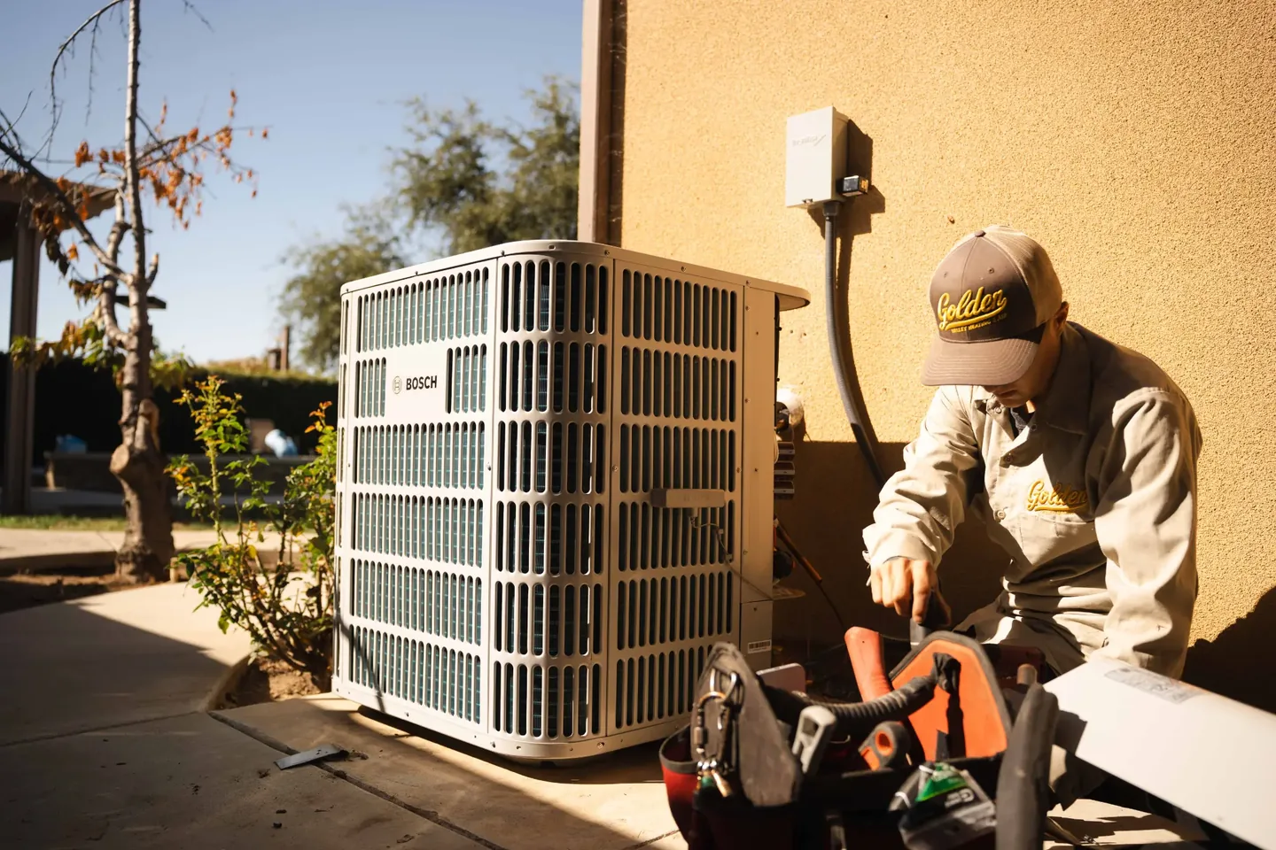 Golden Valley Heating and Air technician servicing outdoor air conditioning equipment — photo 3
