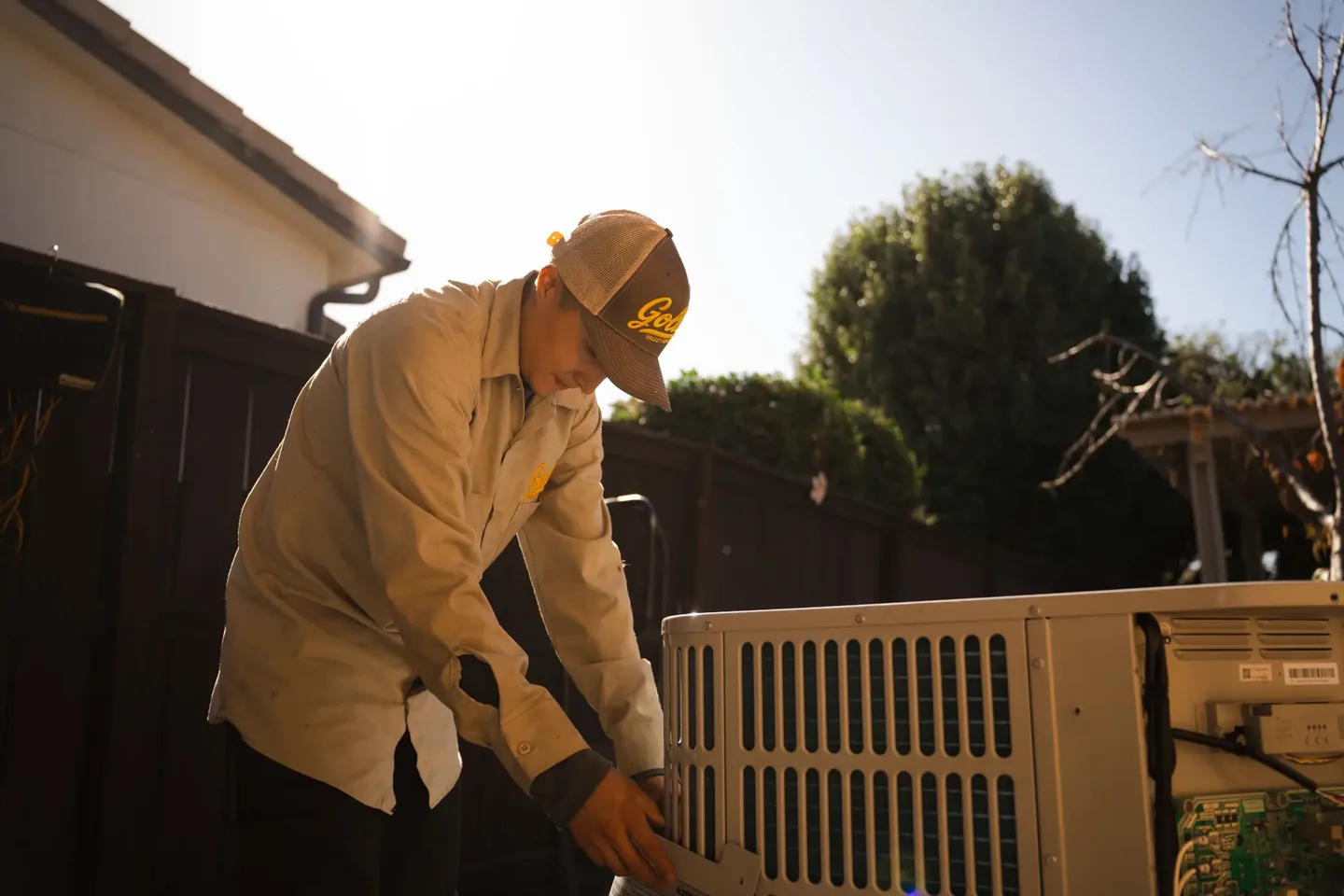 Golden Valley Heating and Air technician servicing outdoor air conditioning equipment — photo 10