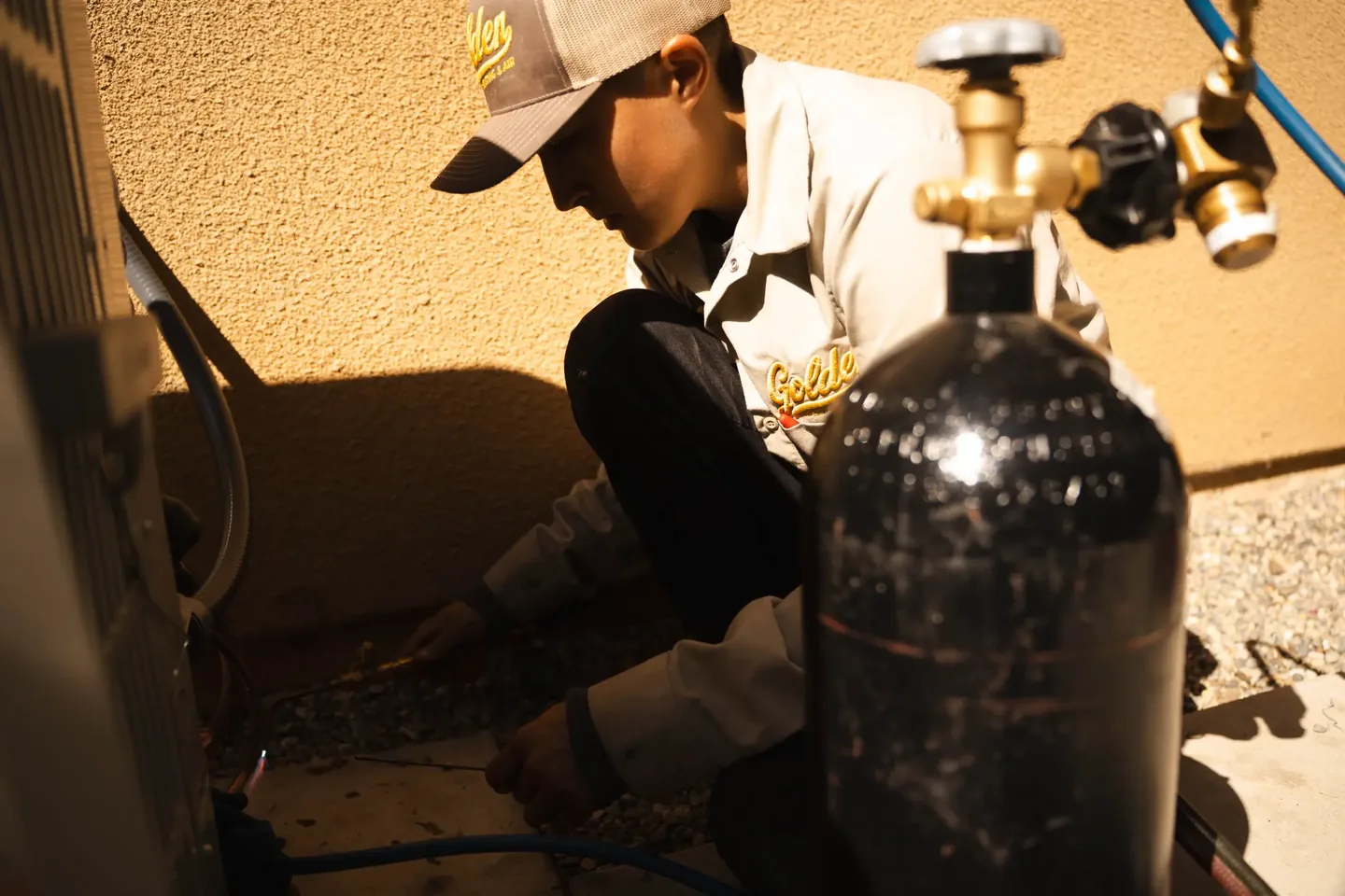 Golden Valley Heating and Air technician servicing outdoor air conditioning equipment — photo 15