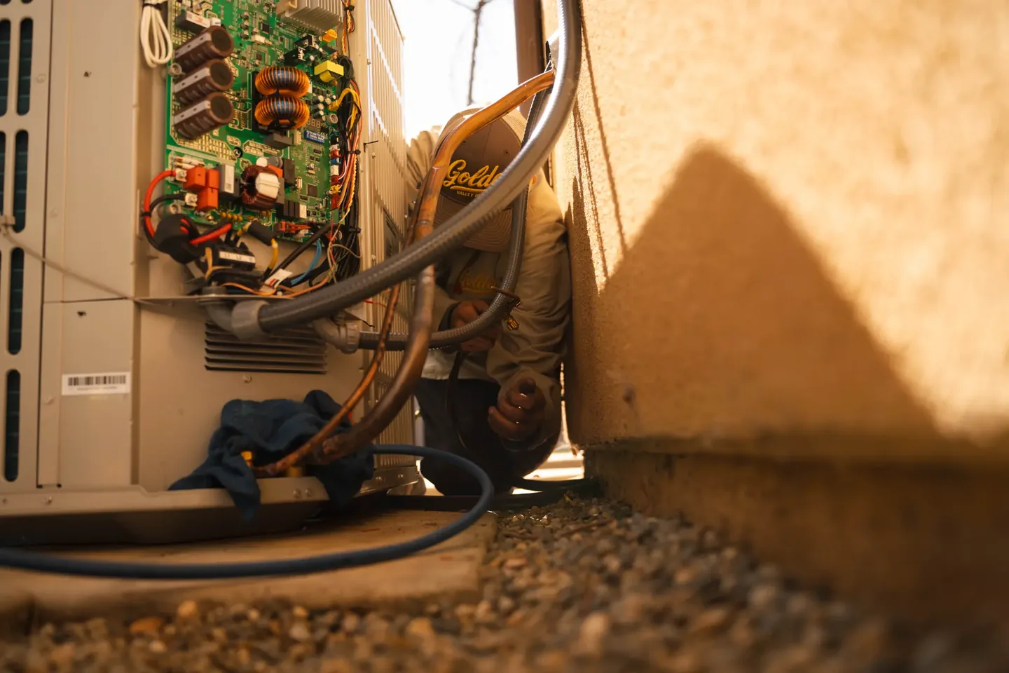 Golden Valley Heating and Air technician servicing outdoor air conditioning equipment — photo 18